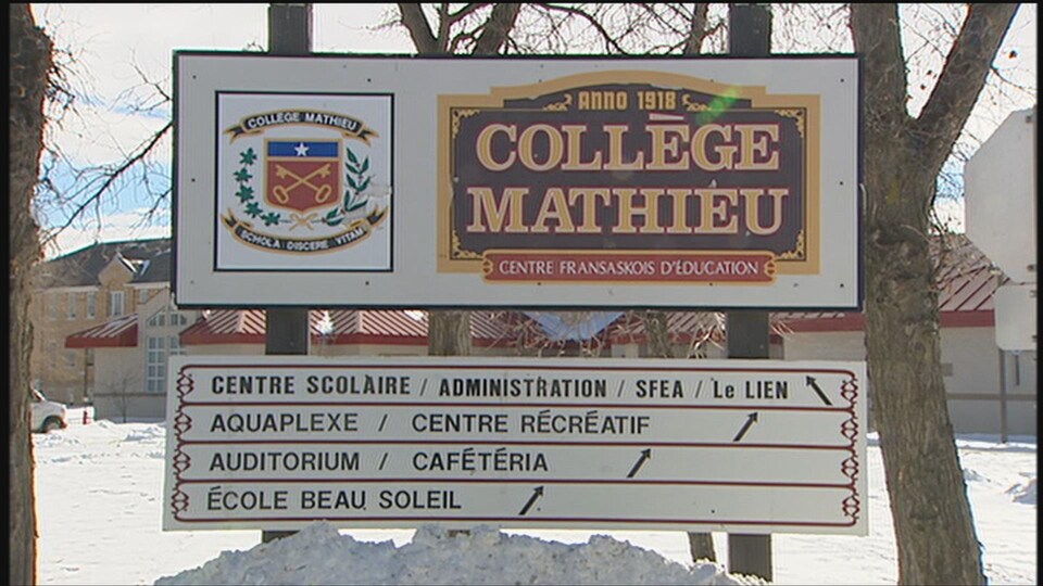 Une grande pancarte affichant la devise du Collège Mathieu avec, en dessous, des indications pour se rendre aux différents pavillons.