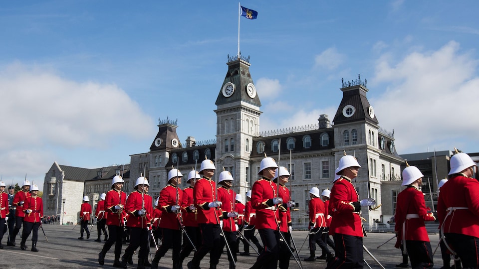 Des élèves officiers en uniforme lors d'une parade militaire devant le collège.