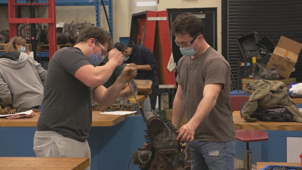 Des étudiants du programme de conception de produits automobiles travaillent sur des moteurs dans une classe laboratoire au Collège St-Clair. 