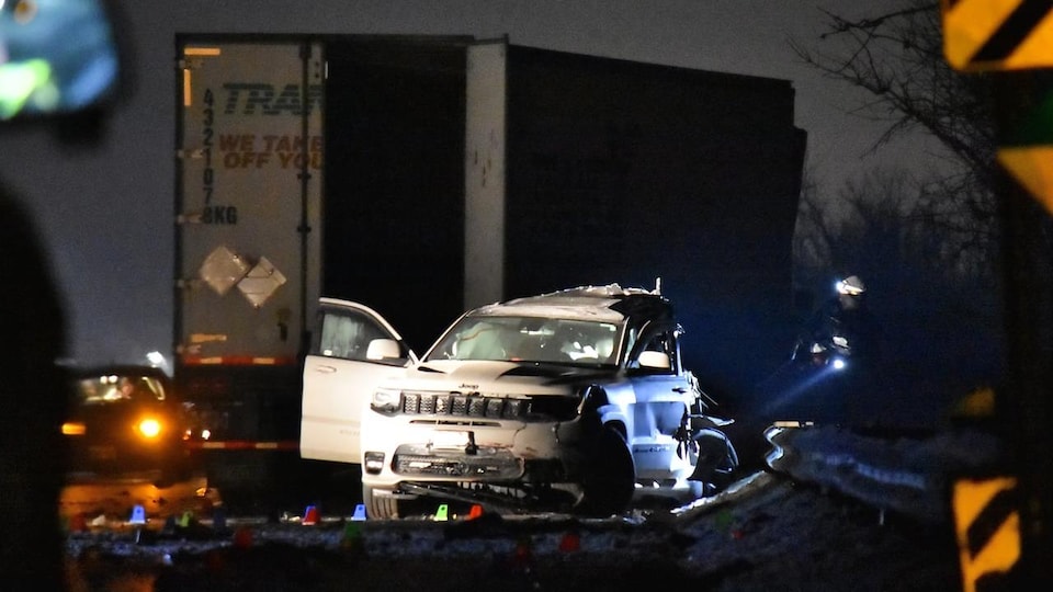 La Jeep accidentée à côté de la remorque du camion.