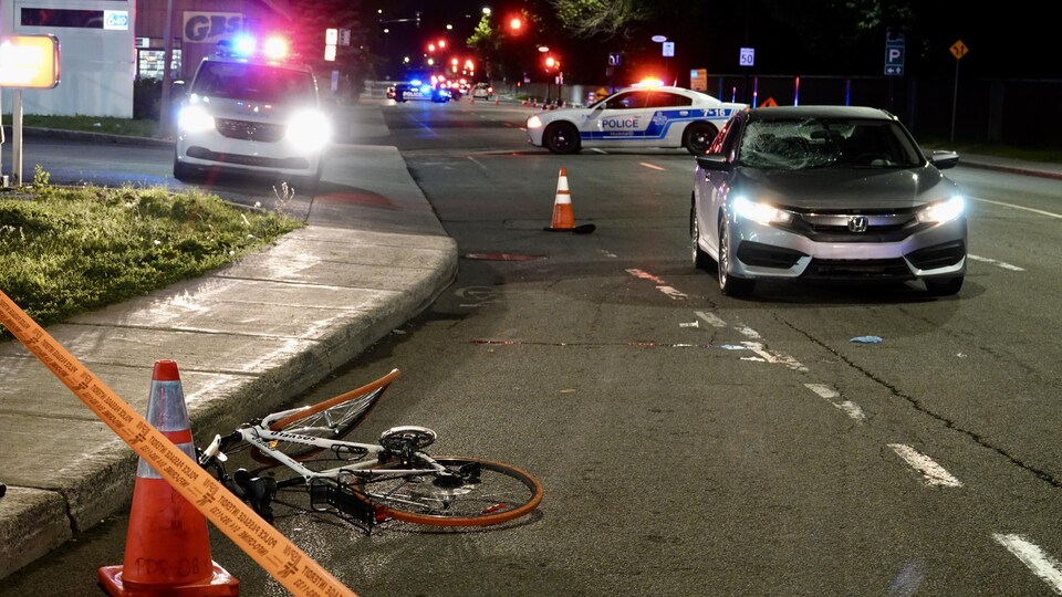 Les policiers ont délimité la scène d'un accident entre une automobile et un vélo.
