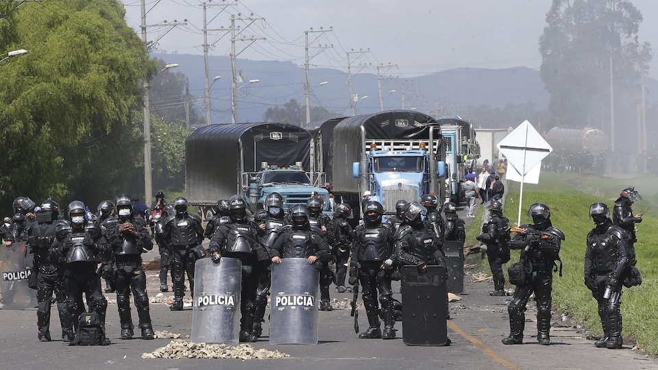 Agentes de policía frente a una barrera para camiones. 