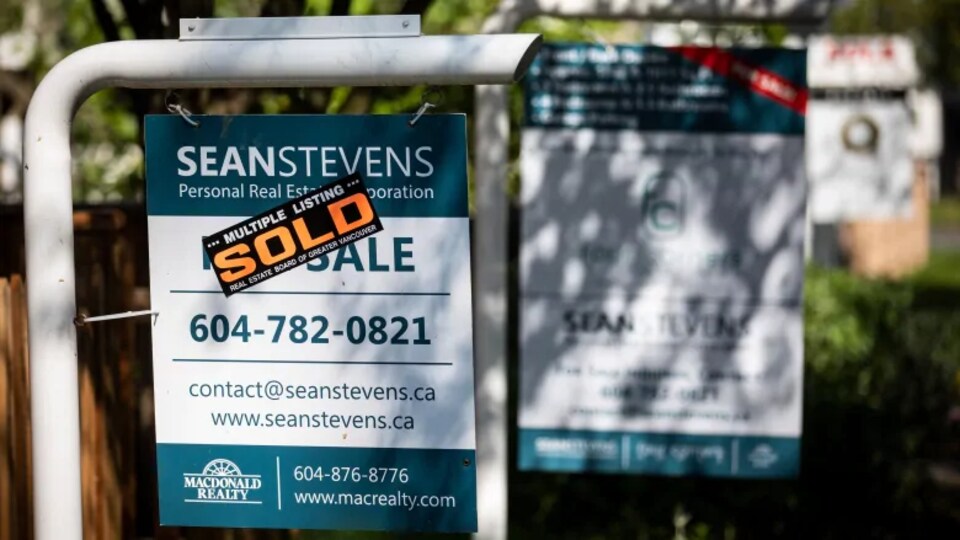 Une pancarte où il est inscrit «vendu» devant une maison.
