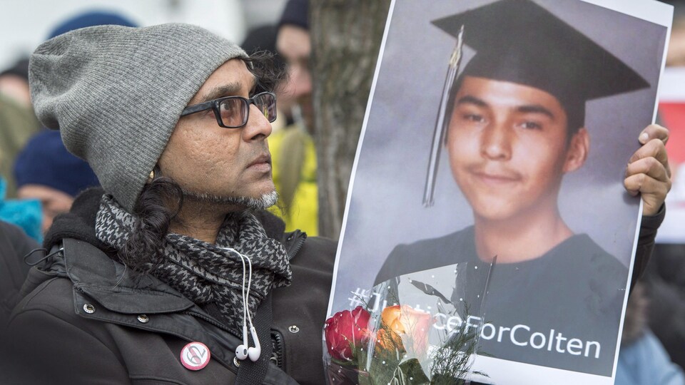 Un homme tient une photo de Colten Boushie lors d'une manifestation à Montréal.