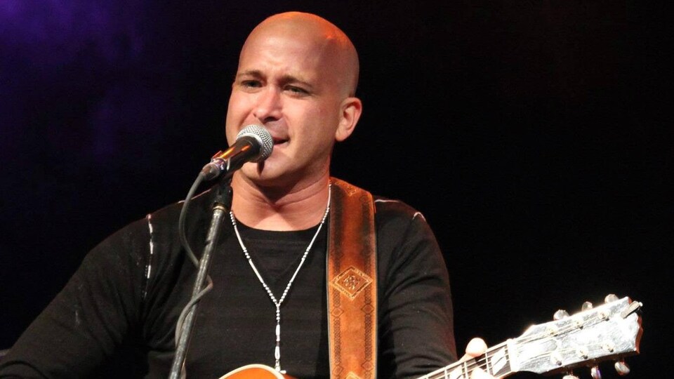 Jacques Comeau sur scène, chante et joue de la guitare