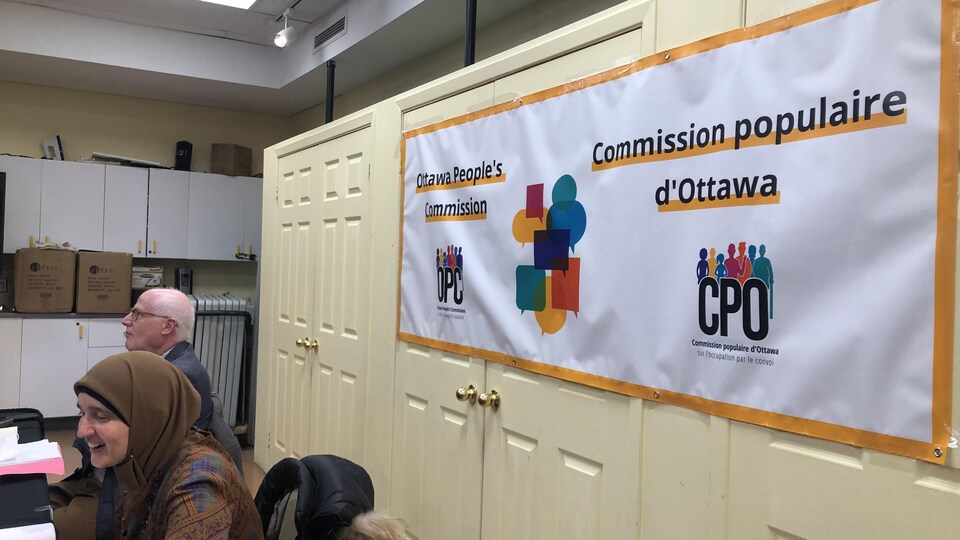 Une affiche de la Commission populaire d'Ottawa est attachée à des portes de placards.