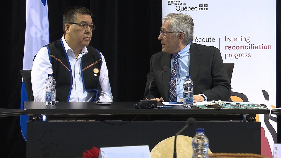 Mike McKenzie et Jacques Viens discutent ensemble lors d'une audience de la commission.