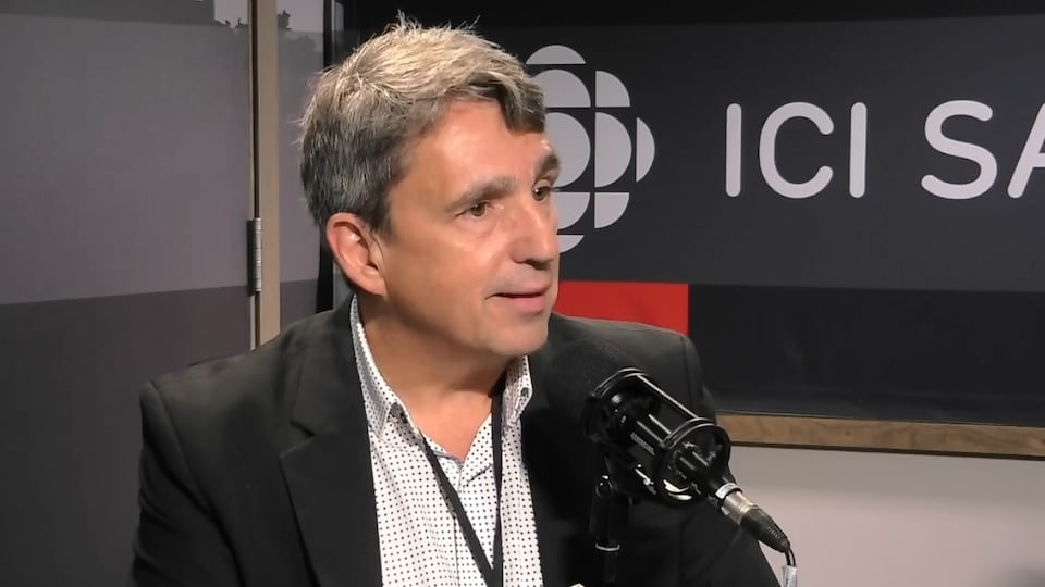 Un homme aux cheveux poivre et sel en entrevue à Regina, en Saskatchewan