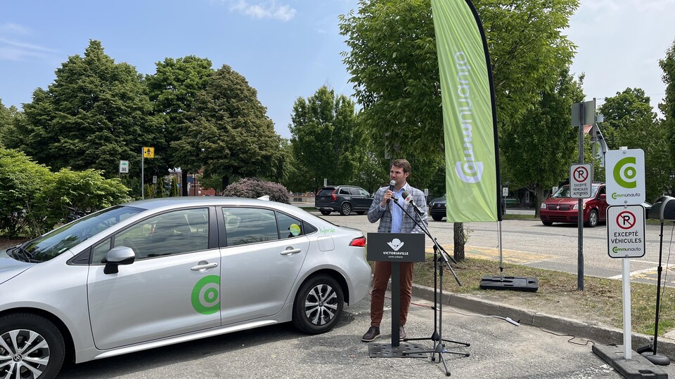 Un homme avec une voiture dans un stationnement