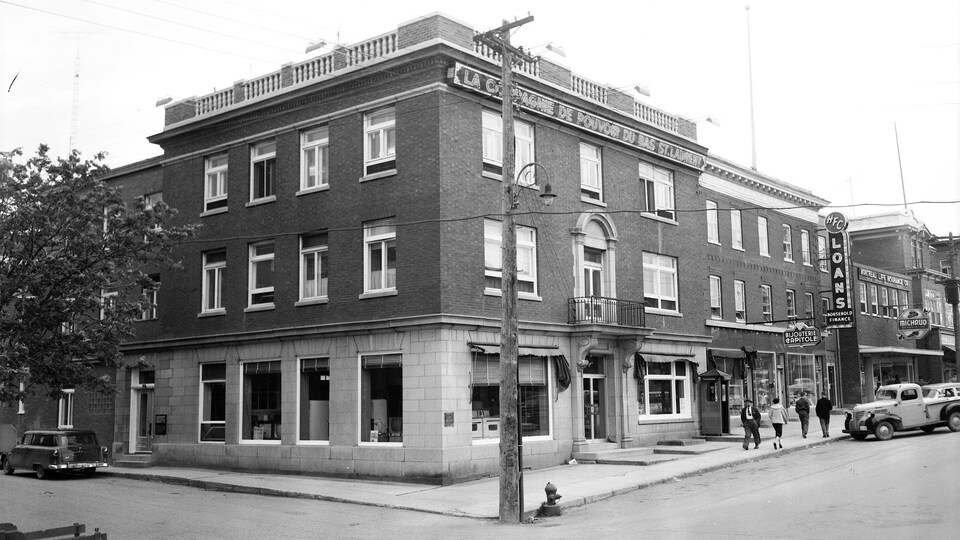 Photo d'archives d'une série d'immeubles alignés, avec leur façade sur un large trottoir. 
