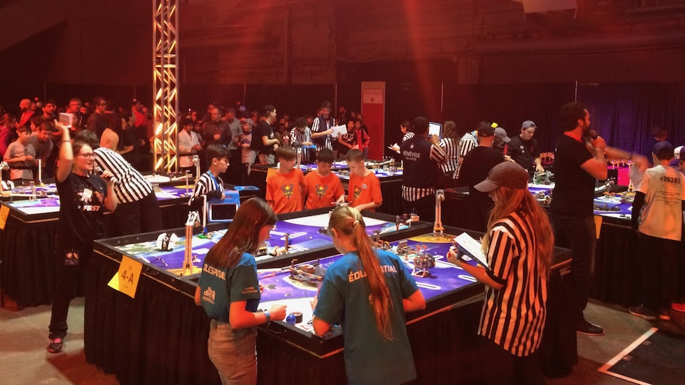 Jeunes autour d'une table pour faire fonctionner leur robot.