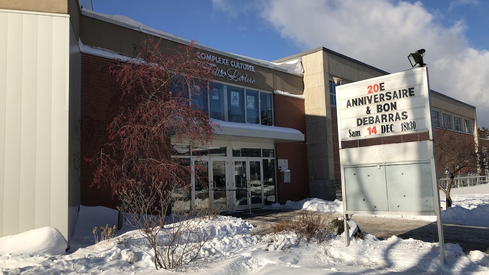 L'extérieur du complexe en hiver avec une affiche annonçant le 20e anniversaire.