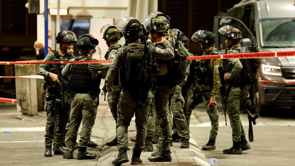 Un groupe de policiers israéliens lourdement armés dans un périmètre de sécurité.