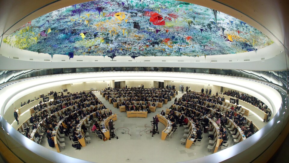 Des diplomates dans une grande pièce ronde dont le plafond est couvert d'une fresque multicolore.
