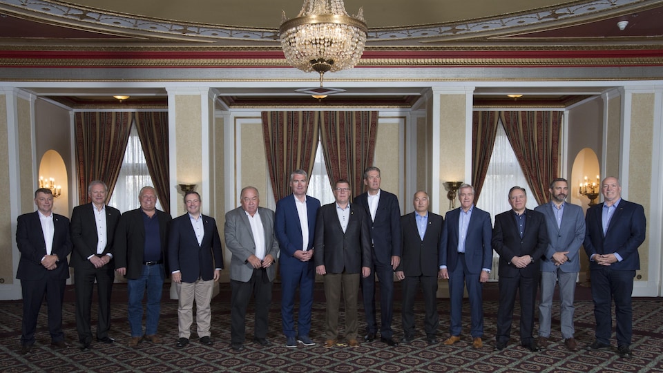 Les 13 premiers ministres canadiens photographiés l'un à côté de l'autre au Conseil de la fédération à Saskatoon.