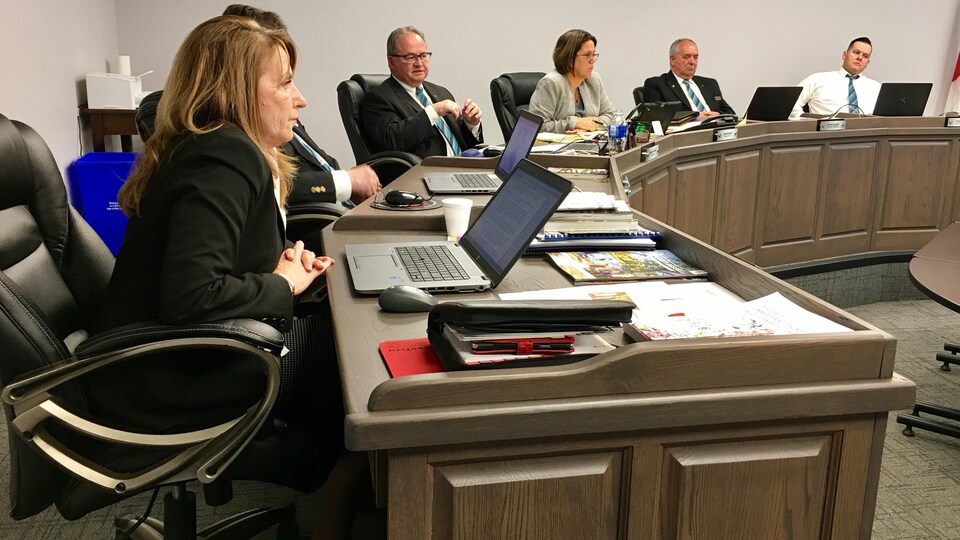 La conseillère Marie-Noëlle Lanthier est assise à la table du conseil municipal devant son ordinateur.