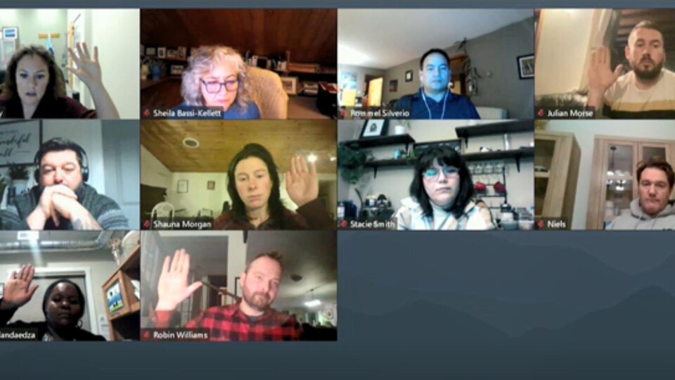 Cinq personnes lèvent la main dans une rencontre virtuelle. 