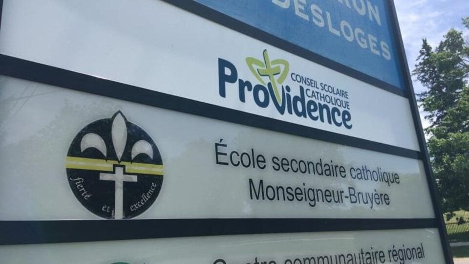 Un grand panneau avec le logo de l'école et du conseil scolaire.