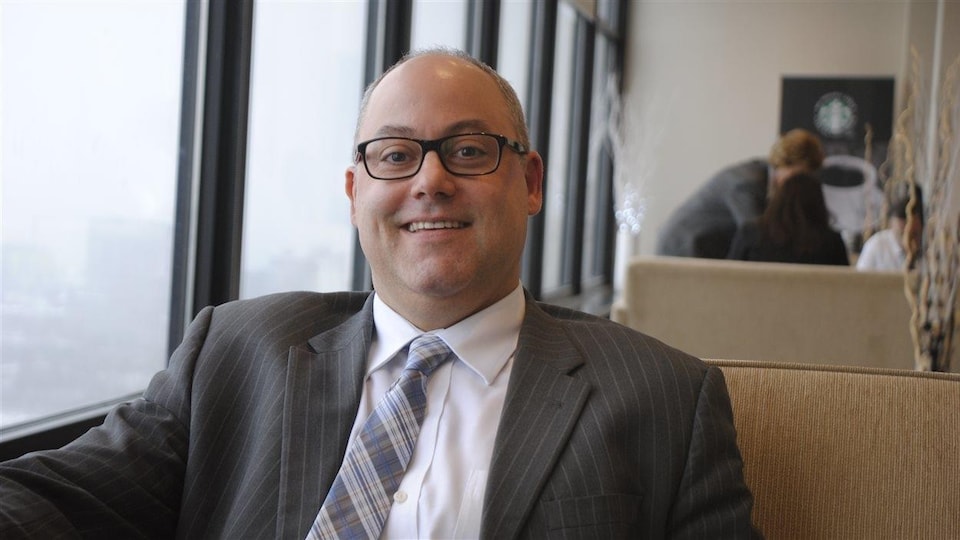Le directeur général du Conseil scolaire Centre-Est de l'Alberta, Marc Dumont pose pour la caméra assis dans un café.