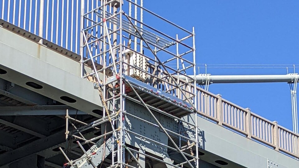 Une structure d'acier attachée sur la structure d'un pont.