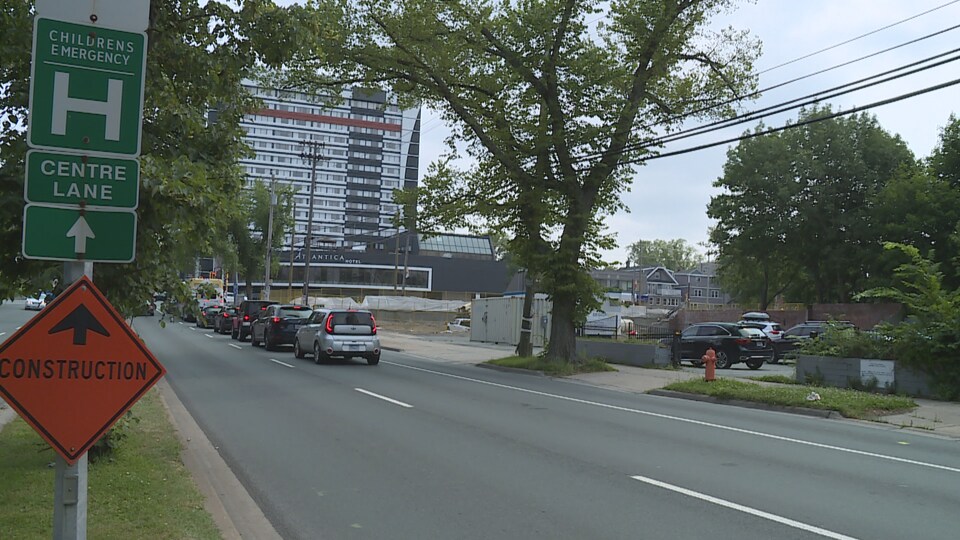 Une rue d'Halifax avec un panneau sur lequel est écrit « construction ». Il y a un arbre de l'autre côté de la rue.