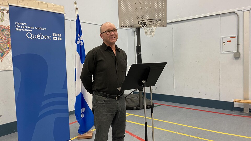 Réjean Richad parle au lutrin dans le gymnase de l'école de La Motte.