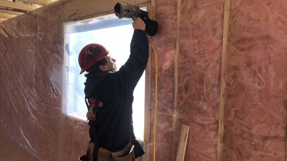 Un travailleur dans une maison en construction.