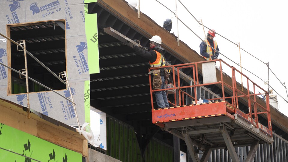 Des travailleurs de la construction s'activent sur un chantier.