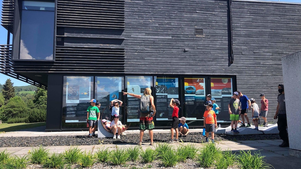 Des enfants devant un bâtiment en été.