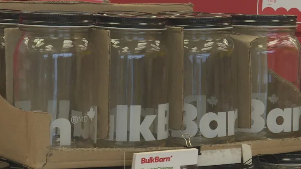 Des bocaux vides avec la marque Bulk Barn engravée dessus.