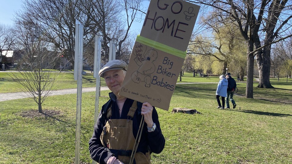 A woman is walking with a sign.