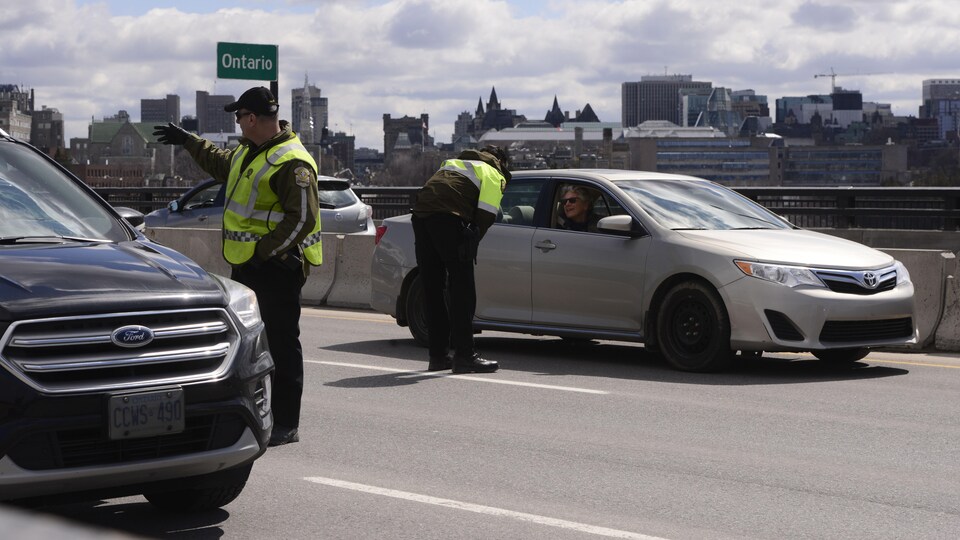 Un policier de la Sûreté du Québec qui intercepte les automobilistes.