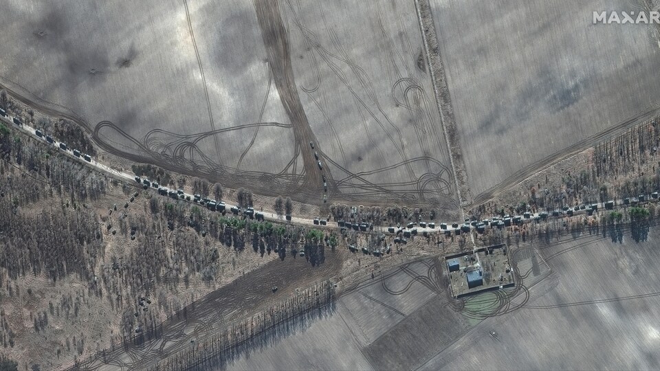 Une longue colonne de véhicules militaires russes sur une route rurale vue des airs.