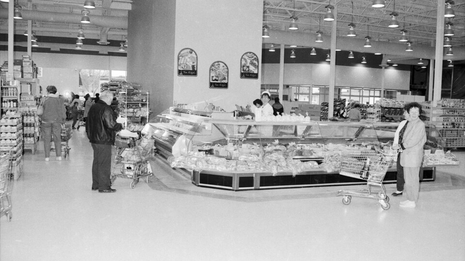 Photo en noir et blanc de personnes faisant leurs courses dans une épicerie.