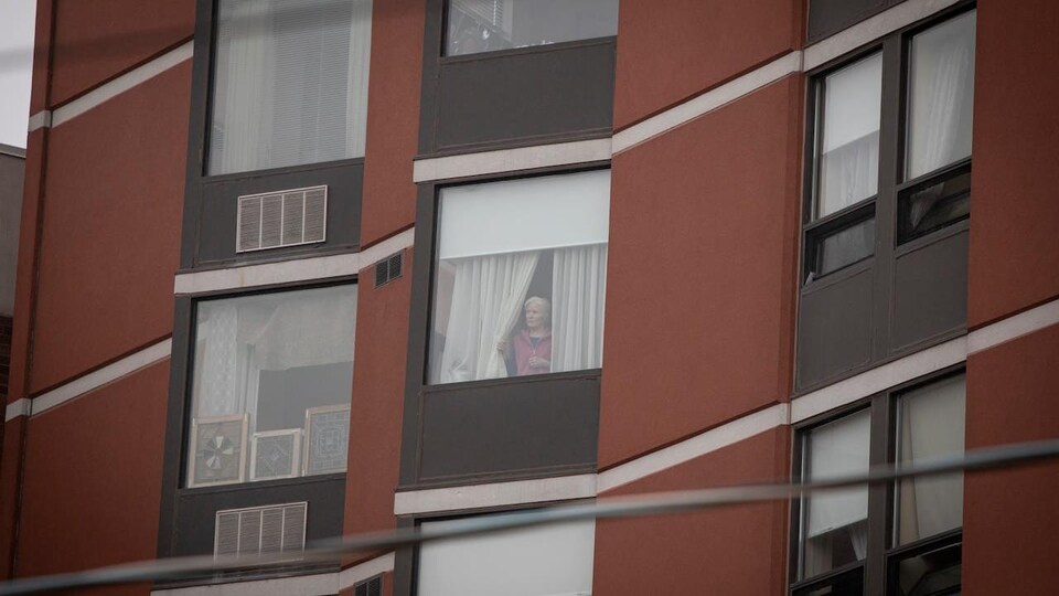 Une femme regarde par la fenêtre