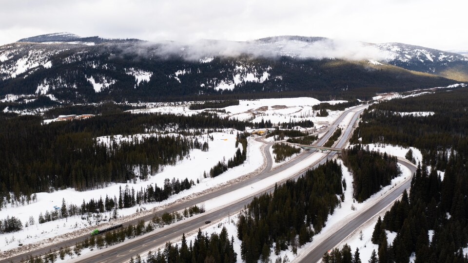 Une autoroute se faufile dans un secteur boisé et montagneux.