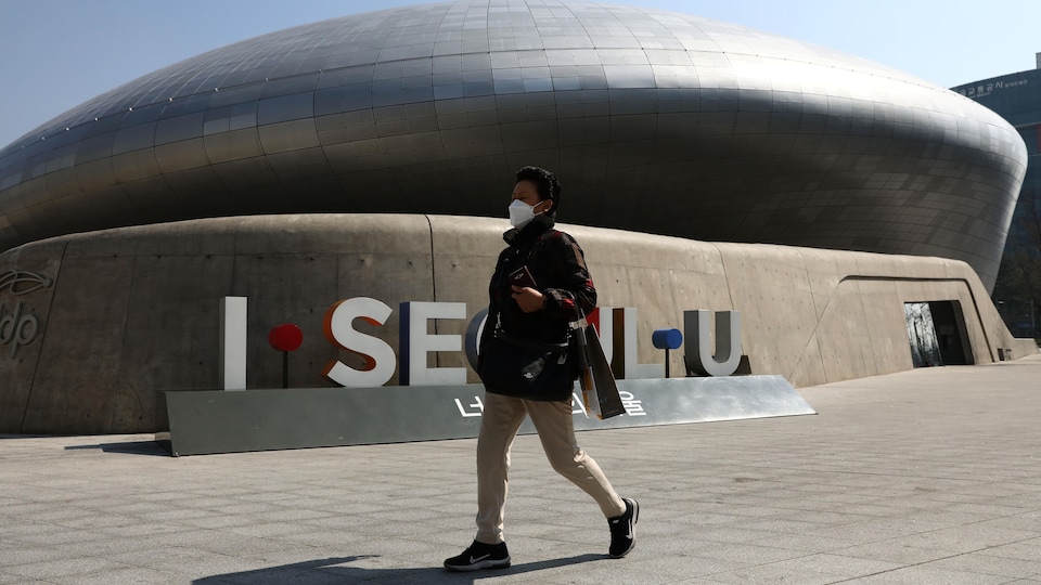 Une femme sud-coréenne porte un masque pour se protéger du coronavirus, le 18 mars 2020, à Séoul.