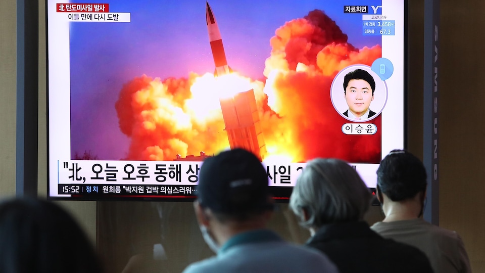 Des personnes regardent une télévision montrant une image d'un lancement de missile.