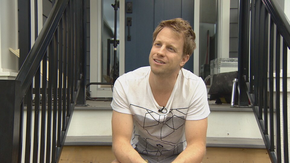 Corey Loranger est assis sur les marches d'un escalier extérieur.