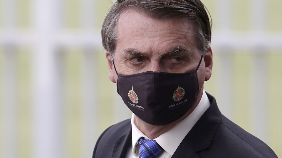 Jair Bolsonaro porte un masque noir.