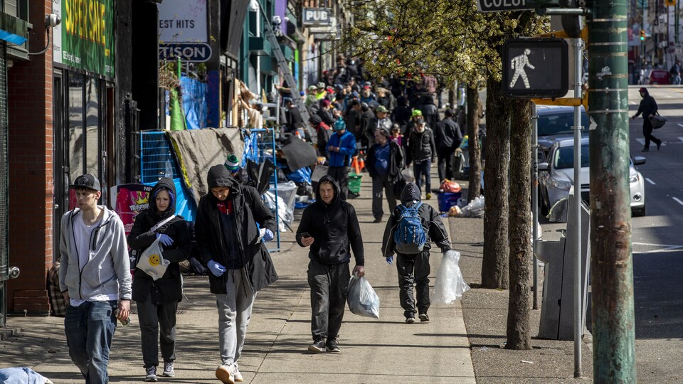 Des gens marchent dans le quartier Downtown Eastside à Vancouver, 