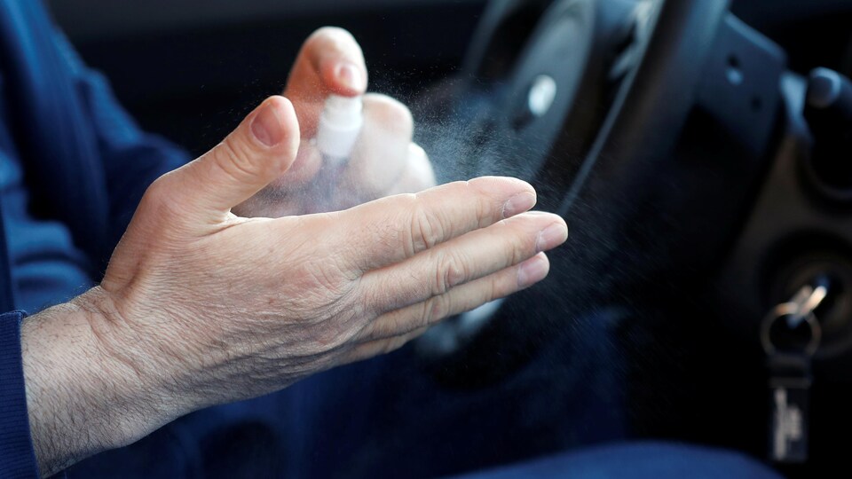 Un chauffeur de taxi se nettoie les mains avec du désinfectant.