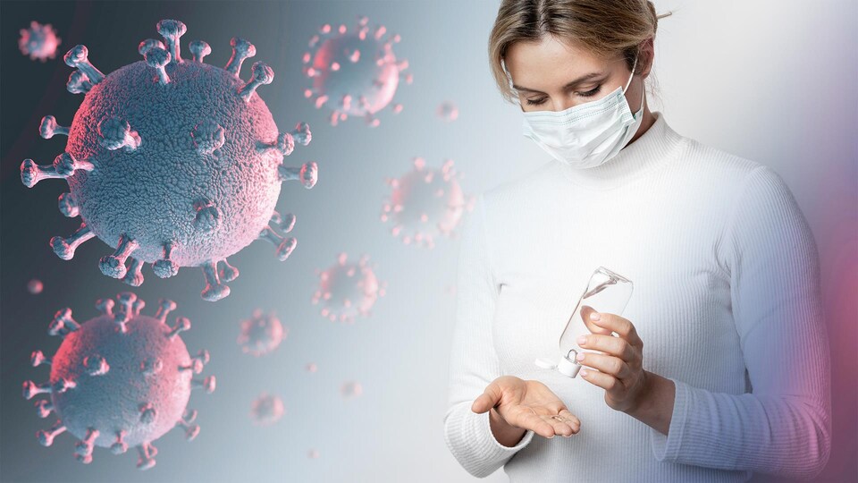 Une dame portant un masque chirurgical se met du désinfectant dans la main.