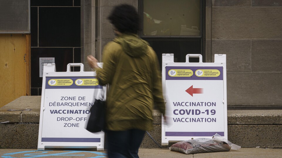 Une femme passe devant un centre de vaccination.