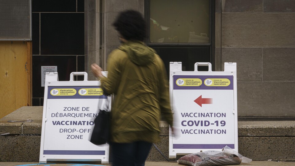 Une personne marche dans la rue en direction d'un centre de vaccination.