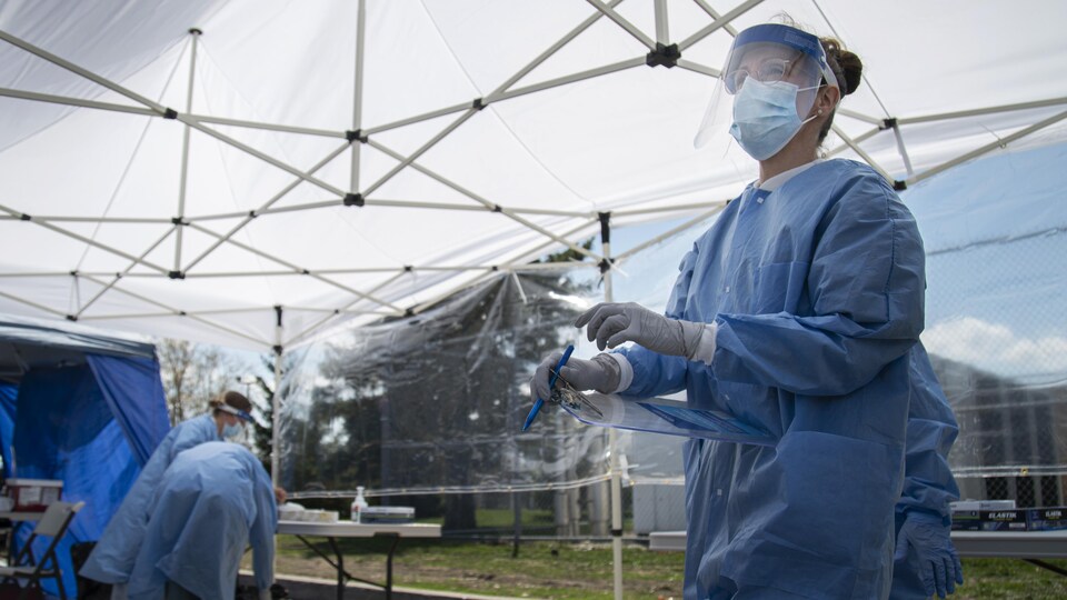 Des professionnelles de la santé sous une tente blanche.