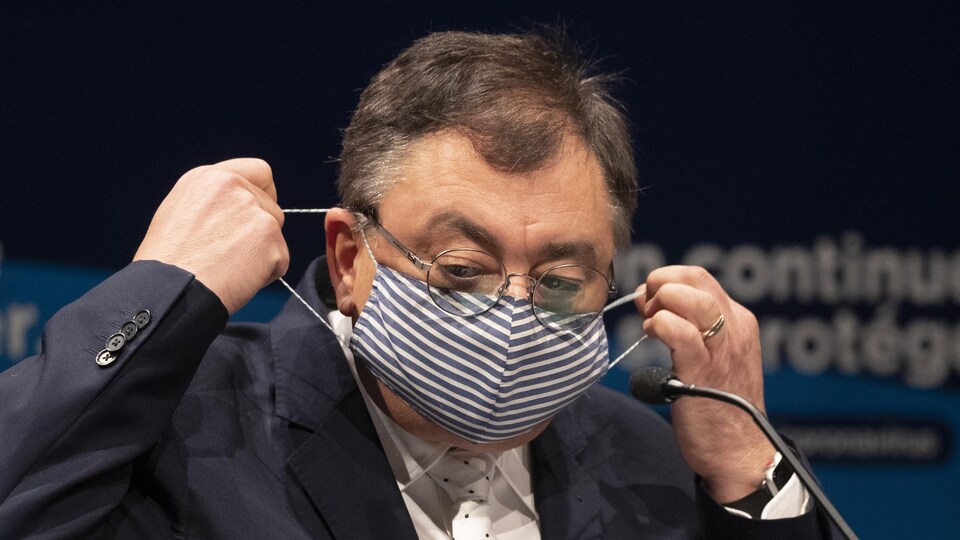 Le directeur de la Santé publique du Québec, le Dr Horacio Arruda, se met un masque.