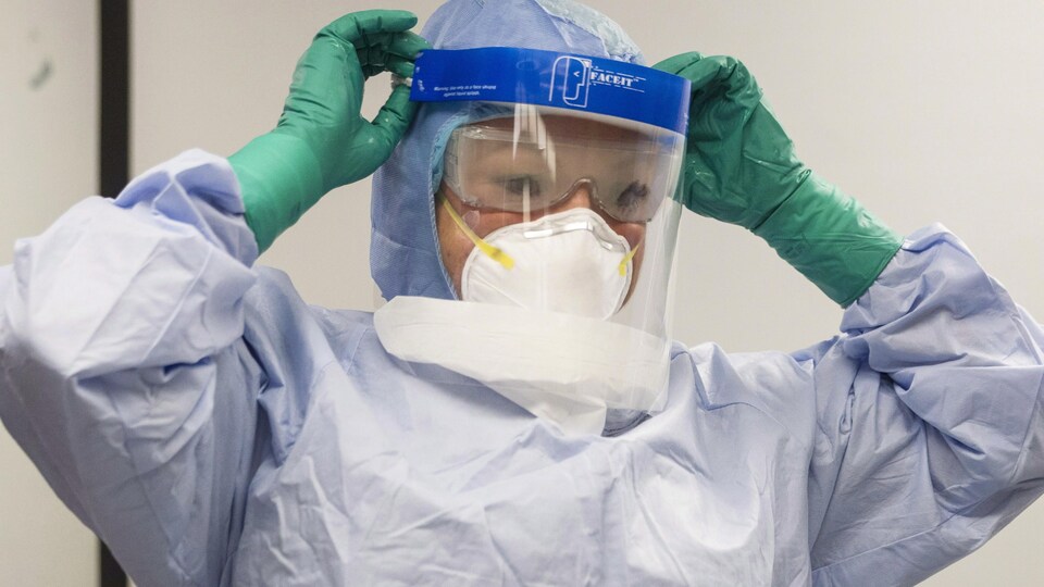 Un médecin équipé de gants et d'un masque total