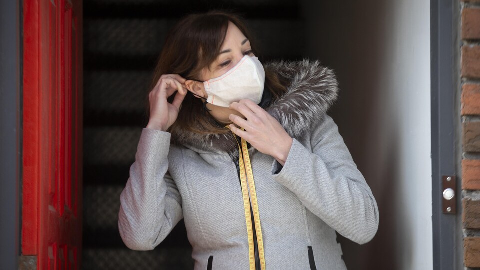 Jackie Zegray dans la porte d’entrée de son logement, en manteau et portant un masque de protection.

Le 15 Avril, 2020    2020/04/15