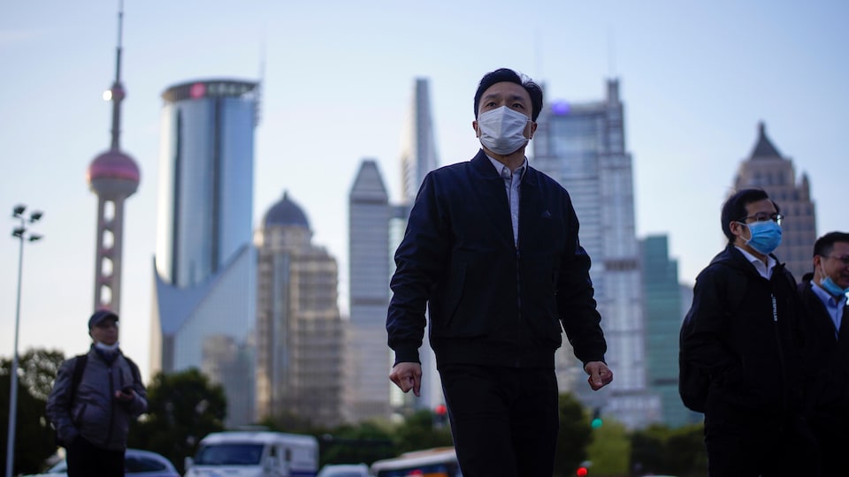 Des gens marchent dans le quartier financier de Shanghai.